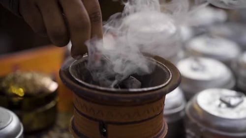 Incense being Placed in Ornate Terracotta Burner