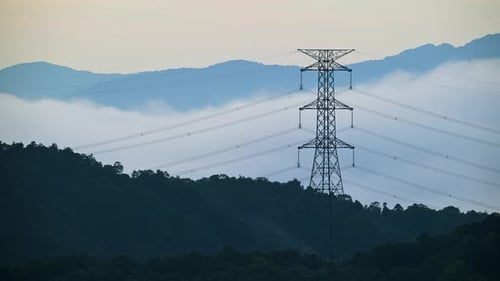 A high voltage tower and a sea of raging, tumbling clouds on a summer morning.