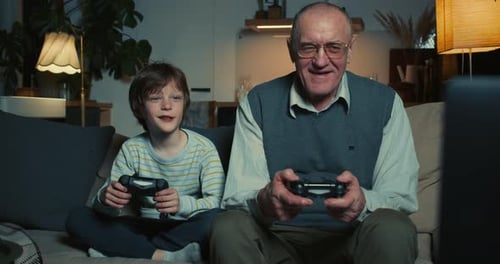 Grandfather and Grandson Play Video Games at Home
