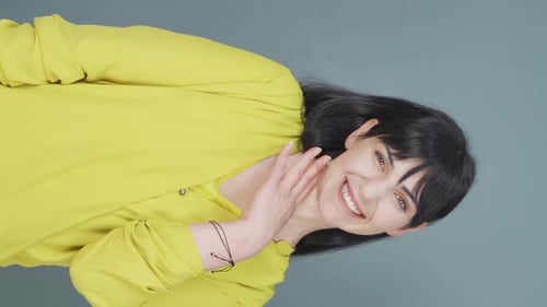 Woman Smiling and Waving Hello at Camera