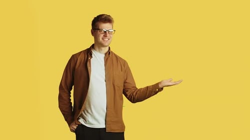 Young Adult Male Presenting on Yellow Background