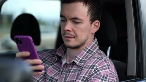 Young Adult Using Smartphone in Car