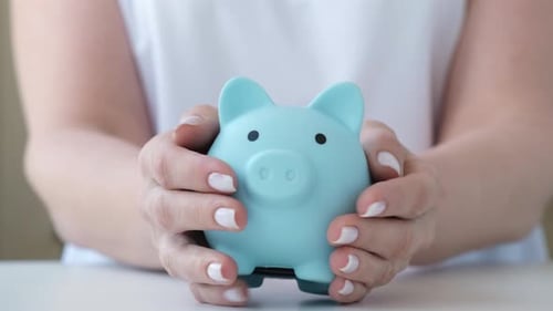 Woman Picks Up a Piggy Bank Saving Money Wealth and Financial Planning Concept