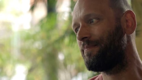 Young man enjoying a refreshing beer and relaxing at an outdoor cafe