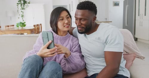 Couple Relaxing at Home Looking at Phone Together