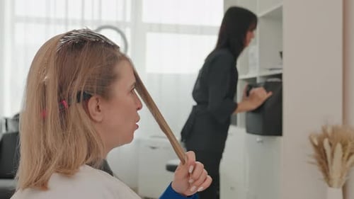 Woman coloring hair in salon workplace setting