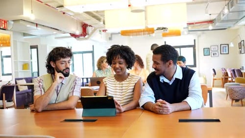 Diverse Coworkers Collaborating on Tablet in Modern Office