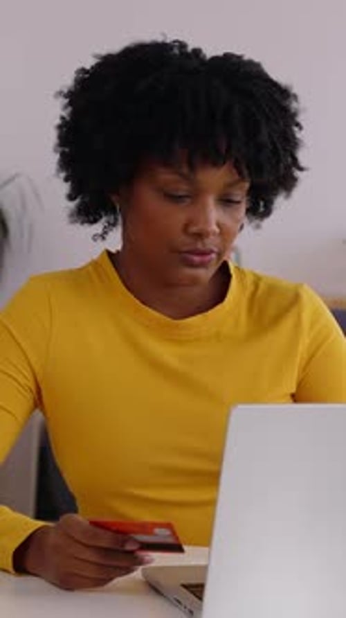 Woman with Laptop and Credit Card at Home