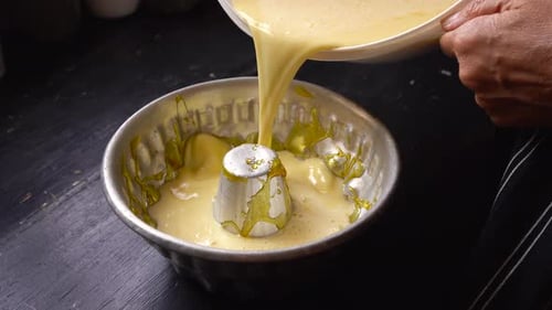 El panadero vierte la mezcla de tarta en un molde de savarin, flan casero