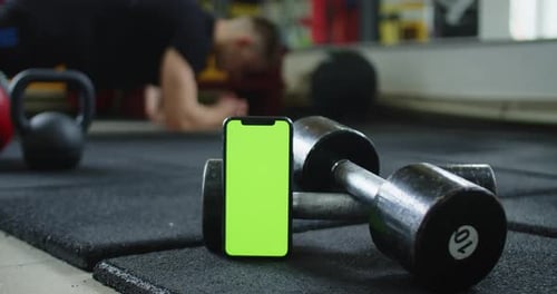 A Video Featuring a Green Screen Smartphone and a Man Doing Ab Exercises in the Background