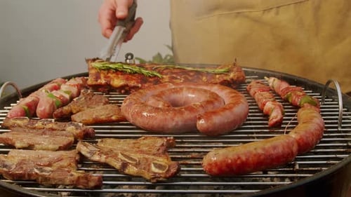 Traditional Spanish Barbeque Big Sausage Chorizo Botifarra Pork and Beef Ribs on Grill with Fire