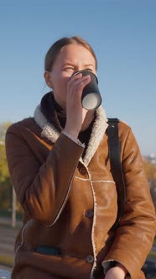 Woman Drinking Coffee Outside on Sunny Day