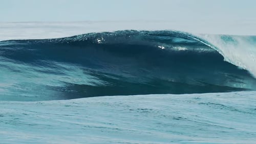 Big glassy ocean wave rolls and breaks in the Maldives