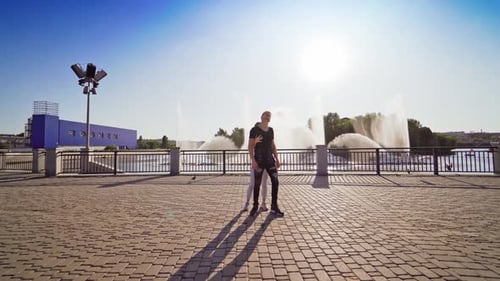 Street dance. Young couple of professional dancers on the background of beautiful fountain outdoors.