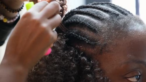 Cabeleireiro fazendo penteado com tranças de crochê em salão de cabeleireiro afro