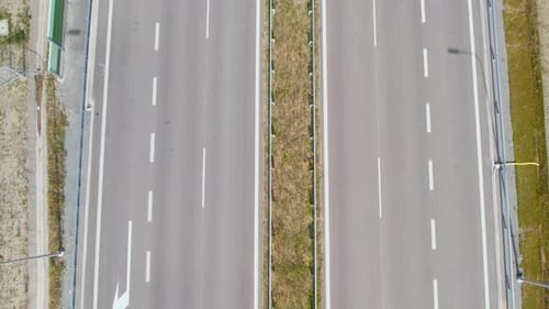 Empty Road With Broken White Line Marks On A Sunny Day. - aerial