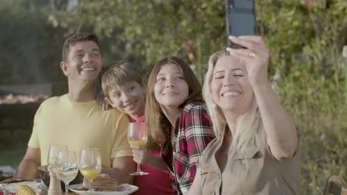 Happy Woman Taking Selfie of Her Family at Garden Party