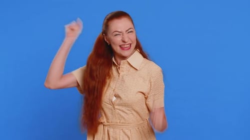 Woman Gesturing Positively in Front of Blue Background
