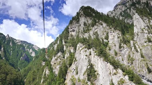 Scenic mountain view with cable car ride. A cable car glides over rocky cliffs