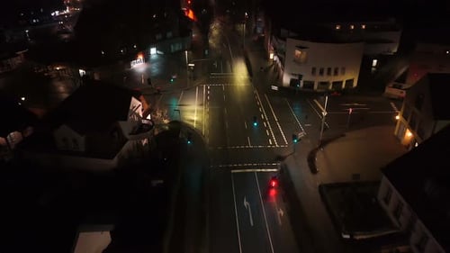 Scooter turning on junction at night. Lighting lantern in small american town. Aerial birds eye top