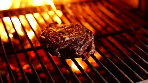 Chef cooks steak on the grill