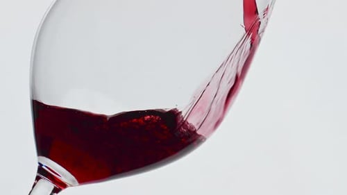 Pouring Red Wine into Elegant Glass Close-up