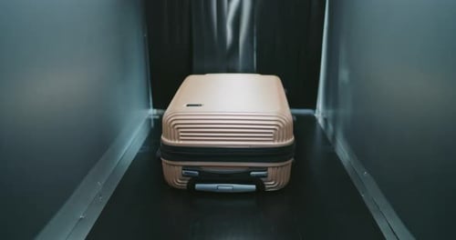 Suitcase Moving Along Conveyor Belt in Tunnel