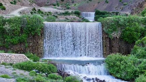 Picturesque Waterfall Cascades Down Stone Terraces in Mountains