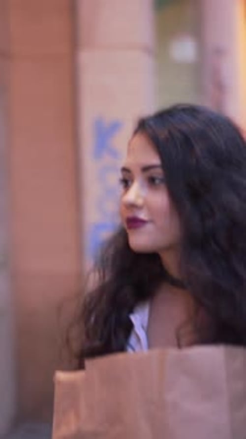 Young Adult Uses Intercom at Night in City