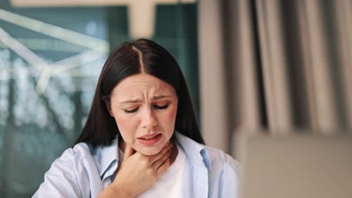 Woman Experiences Sore Throat Pain, Touching Neck