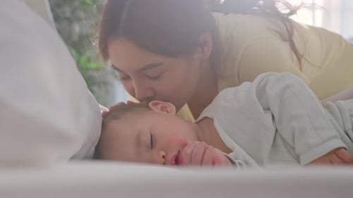 Loving Mother Gaze at Sleeping Infant in Crib