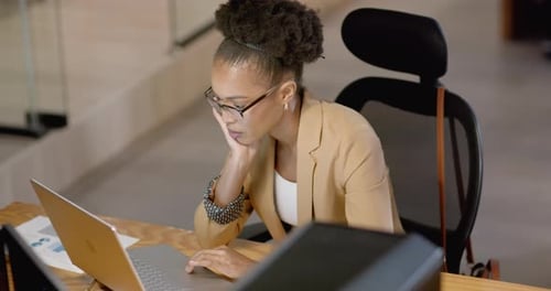 African American business businesswoman focuses on her laptop in an office