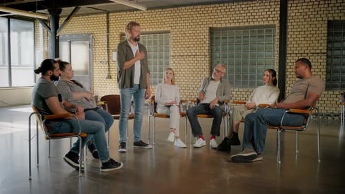 Group Therapy Session with Leader Speaking and Clapping