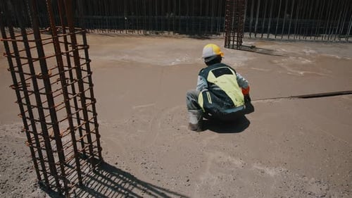Construction Worker Leveling Cement on Construction Site