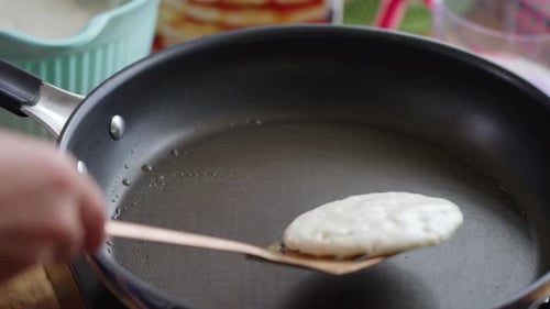 Flipping a Golden Brown Pancake in a Frying Pan