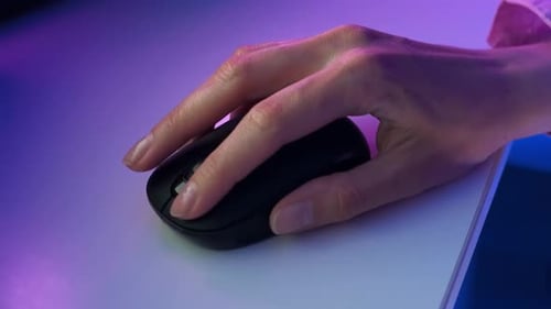 Hand mit der Maus unter Neonlicht auf die linke und rechte Taste klicken