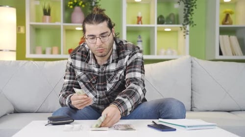 Man Counting Money on Sofa at Home