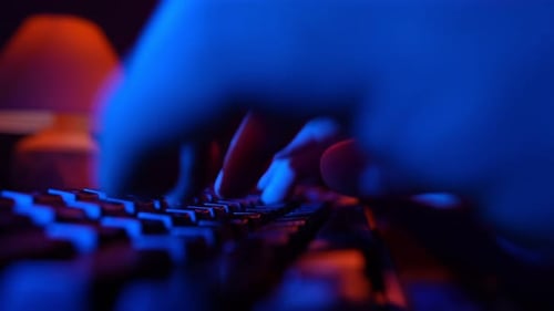 Mann benutzt Computertastaturcode-Website in Neonbeleuchtung