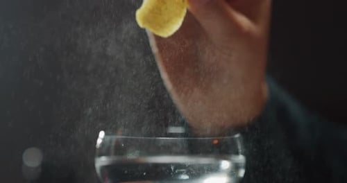 Das Makro eines professionellen Barkeepers ist das Auspressen einer Zitrone bei der Zubereitung eines alkoholischen Cocktails mit