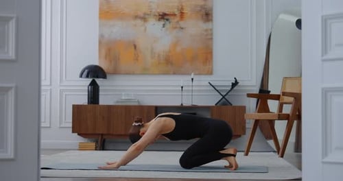 Young Woman Doing Yoga In A Modern Apartment