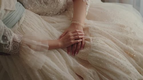 Hands of Bride and Groom on Elegant Dress
