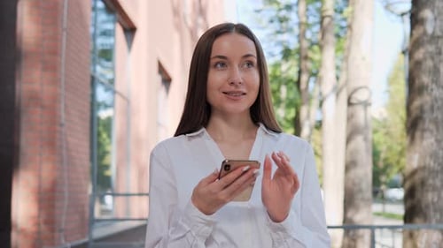 Young Woman Uses Smartphone in City Environment