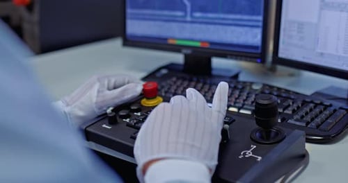 Gloved Hand Operating Complex Scientific Control Panel