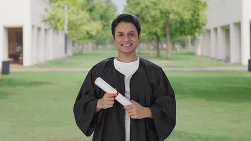 Indian college student throwing cap on graduation