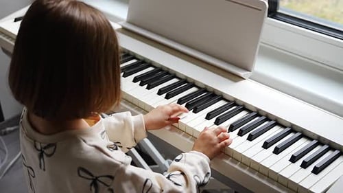 Young Girl Plays Electric Piano at Home