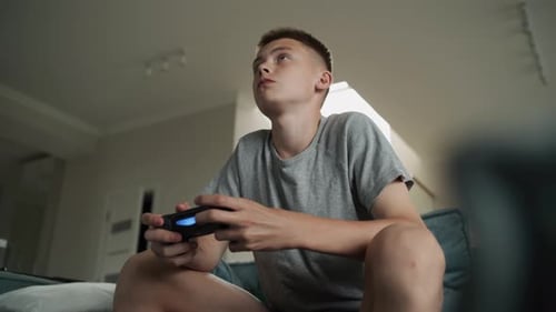 Teenager Plays Video Games at Home