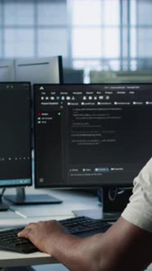 Developer Typing Code on PC to Mend Data Center Racks