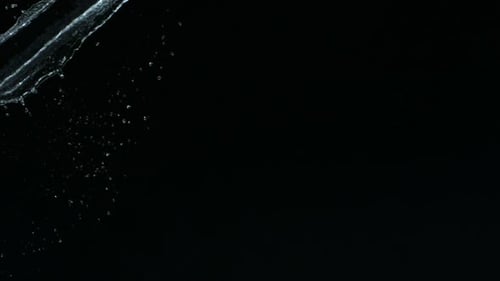 Water Splashing Diagonally Across a Black Background