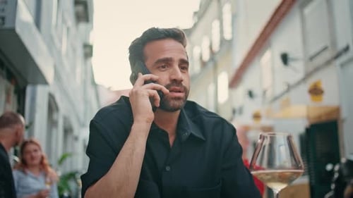 Emotional Tourist Talking Smartphone at City Bar Closeup Man with Alcohol Glass