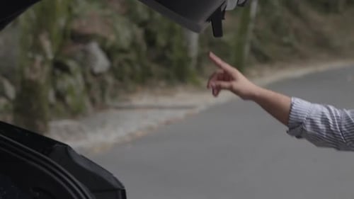 Hand closing car trunk on roadside